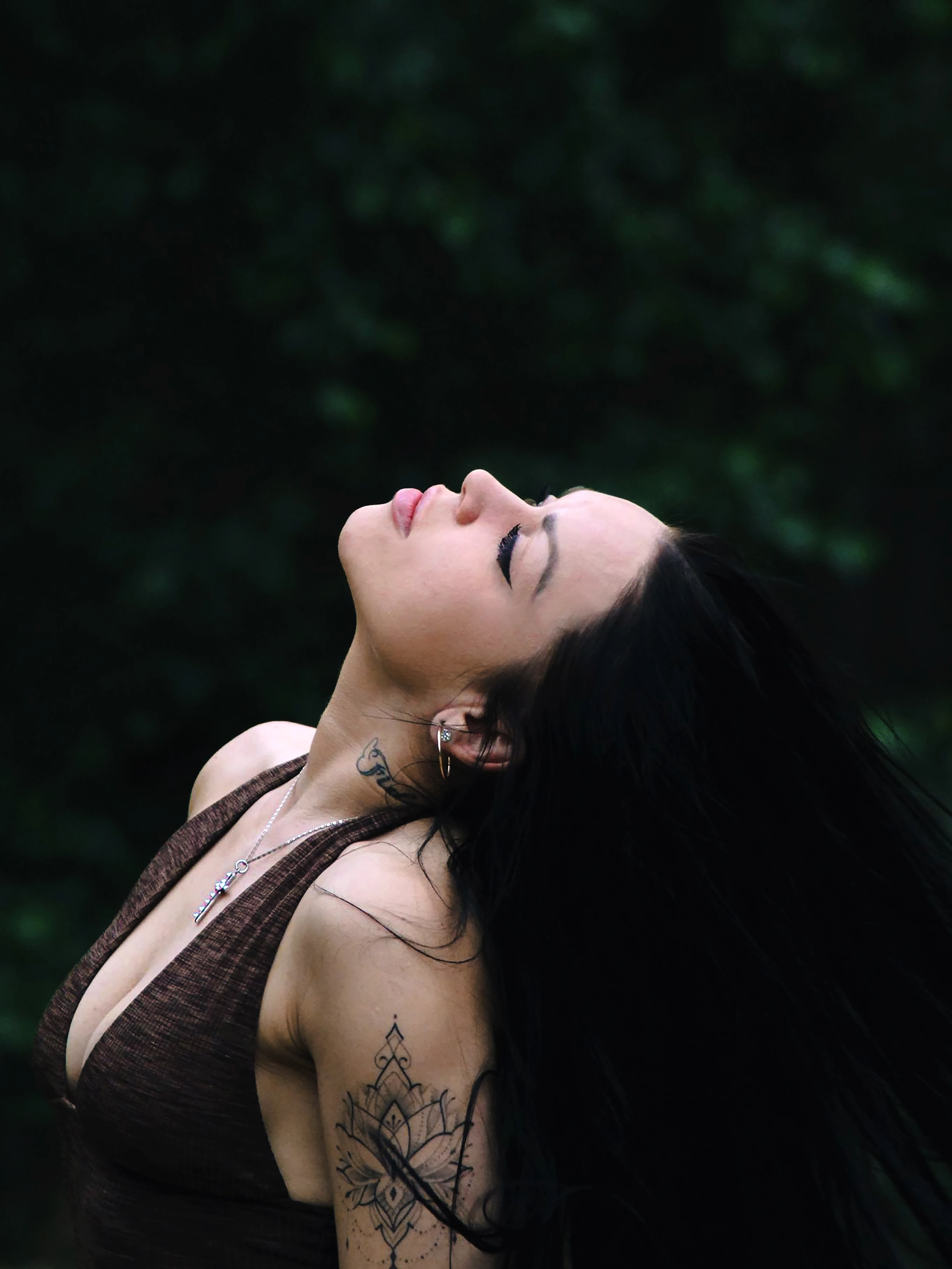 Portret kobiety z zamkniętymi oczami w naturalnym świetle w lesie