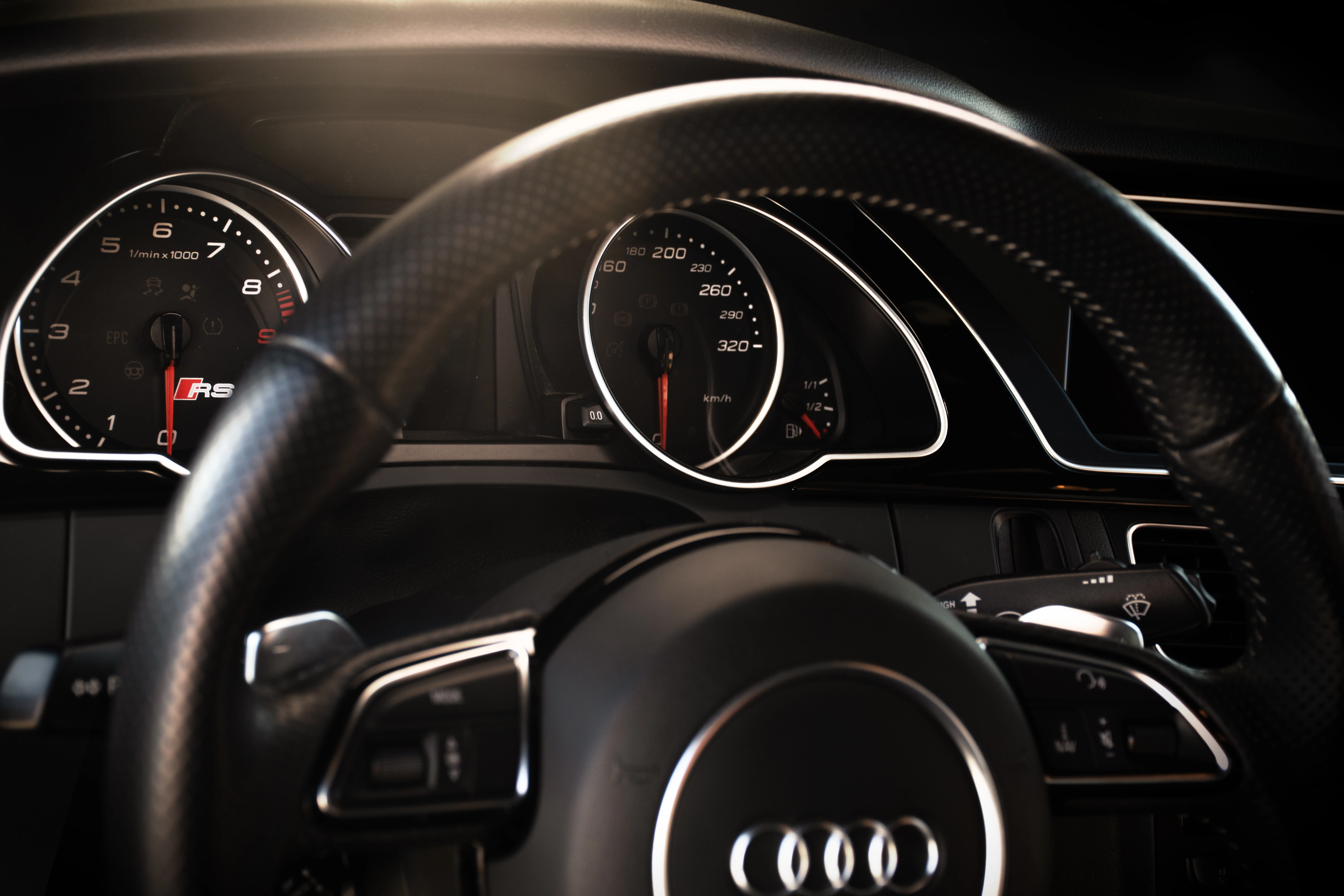 Wnętrze samochodu Audi z widoczną kierownicą i deską rozdzielczą